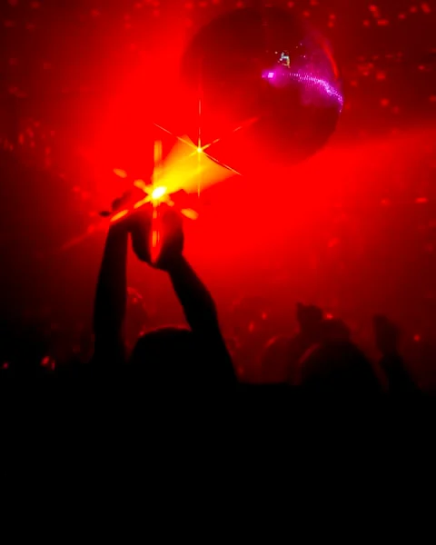 Hands up under red light at a Discoteca night